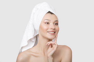 Portrait of a cheerful attractive half-naked young woman with a towel wrapped around her head. White background