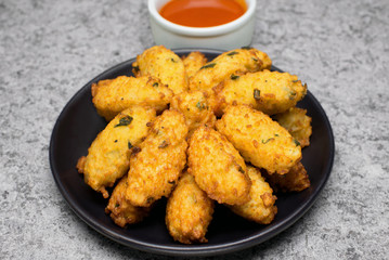 Fried rice balls called bolinho de arroz in a black plate in rustic background