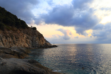 Fototapeta na wymiar Luci del tramonto a capo S. Andrea isola Elba con scogliera e nuvole