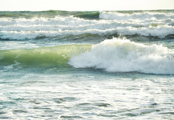 Big foamy sea waves movement on a seashore