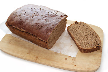 Fototapeta na wymiar Sliced dark rye hemp seed bread on paper and wooden board isolated on white background