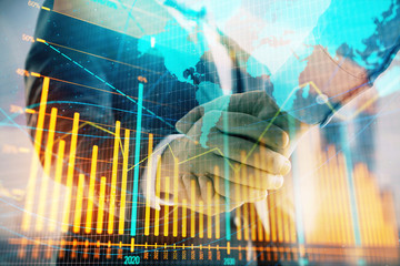 Double exposure of financial chart and world map on cityscape background with two businessmen handshake. Concept of international investment