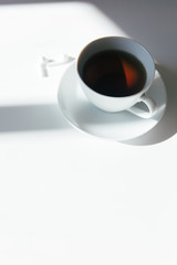 morning tea on a white table with white earphones. Copy space mockup. Clean, quiet and calm morning