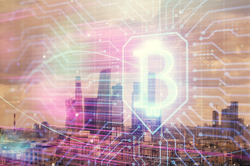 Double exposure of bitcoin sign drawing hologram on cityscape background. Concept of crypto economy