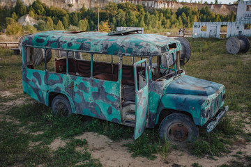 old abandoned bus green in the field