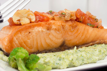 Grilled Salmon fish with broccoli puree and champignon vinaigrette close