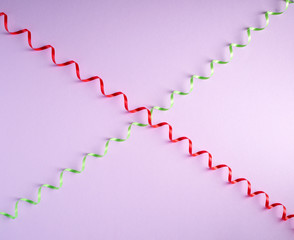 red and green paper serpentine on a lilac background