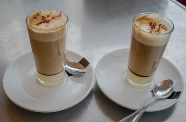 coffee with milk in glass cup on metal table