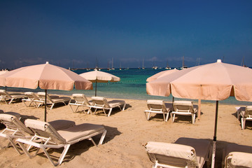 Fototapeta na wymiar Beach umbrellas on the beach in Island Formentera
