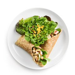 Top view of some colorful and delicious chicken wrap served with salad on a white plate, ready to eat.  