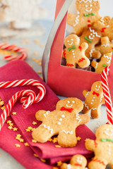 Handmade happy biscuits gingerbread man cookies and candy cane in red gift box on light background.New year and Merry Christmas concept.Vertical orientation