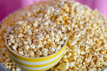 Fototapeta na wymiar A large plate with popcorn on a background of popcorn