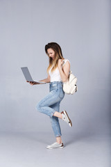 Happy nice-looking successfull student girl rejoices at excellent passing of exam, reads a letter from college by e-mail on laptop. American girl using digital computer for education or communication