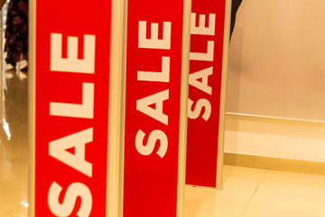 sale sign stands on a rack with things in the store
