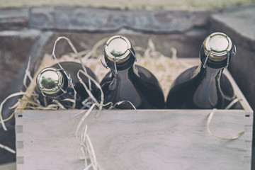 three champagne bottles in a wooden box on a stone wall background