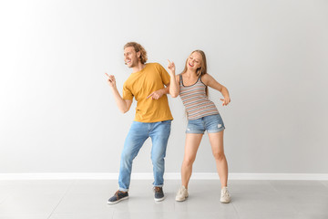 Obraz premium Fajna młoda para tańczy na białej ścianie