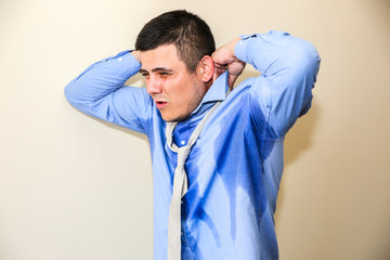 Sweating office worker. Wet shirt. Bad work conditions. Unhappy manager. Summer heat. No air conditioning in the building.