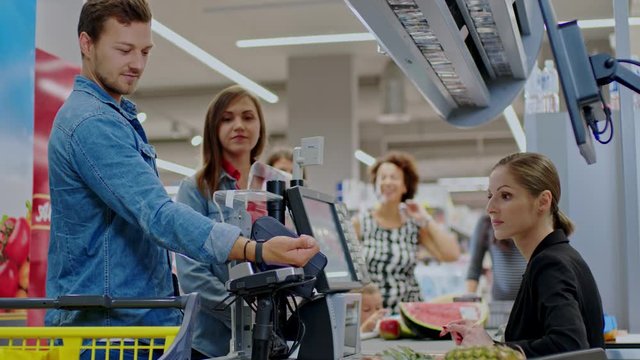 Man paying with a smart watches in a grocery store