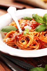 Plate of delicious spaghetti Bolognaise or Bolognese with savory minced beef and tomato sauce garnished with parmesan