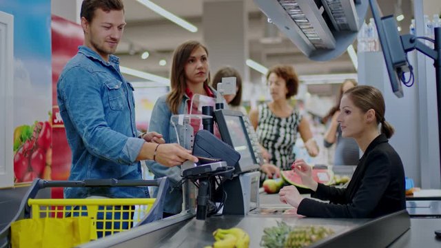 Man paying with a smartphone in a grocery store