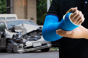 Man holding hand with blue bandage as arm injury with car accident concept. - obrazy, fototapety, plakaty