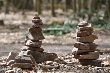 Fototapeta na wymiar A small pyramid of stones made by tourists in the forest Schwarzwald on the background of trees