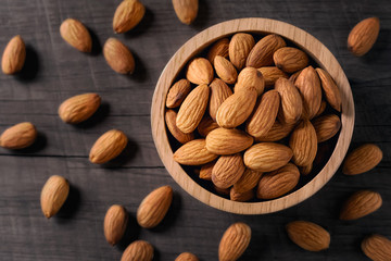 almonds in bowl wood on dark table background