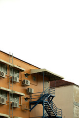 Fototapeta na wymiar Fire escape ladder and air compressor behind the condominium.