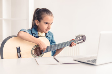 Little girl learning to play guitar online