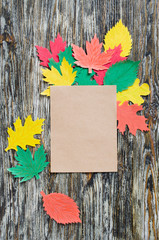 Obraz premium Blank notebook and autumn paper leaves on vintage wooden background. Autumn, fall concept.