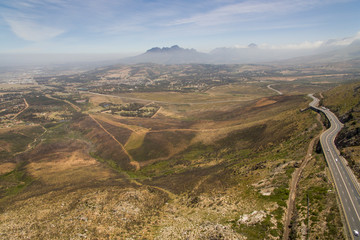 An aerial view over Sir Lowry's Pass, in a North westerly direction. towards Cape Town, with the Helderberg mountain range in the background, and Somerset West and Gordon's Bay in the foreground.