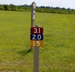 A close view of the colorful mile marker in the field.
