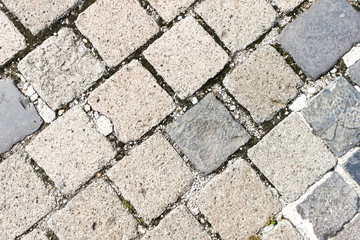 Old granite cobblestone pavement or road pattern texture. Regular rows of granite paving stones background