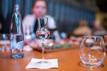 Shot glasses of vodka on a wooden table, addiction to alcohol.