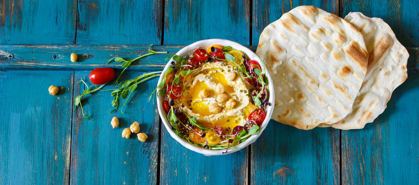 Hummus with olive oil, sprouts and tomatoes