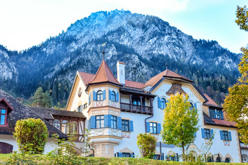 Fototapeta na wymiar Fairytale house with a balcony on a background of a high mountain in autumn in Alps