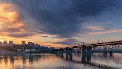 Fototapeta na wymiar Bridge over the Yenisei river, evening sunset. Krasnoyarsk, Russia. panorama of the evening city