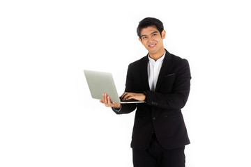 Handsome young businessman Asian caucasian wear a black suit with black hair, be a smile and standing smart poses. hold a computer laptop and use it. On a white background.