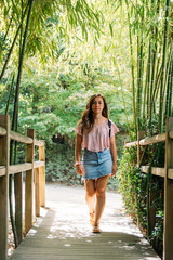 Caucasian pretty girl walking among bamboo poles in a park of France with Japanese theme