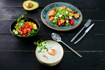 Vegetable cream soup with shrimps and croutons in white bowl close up