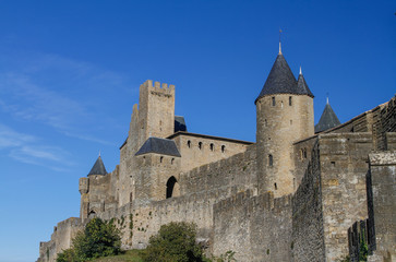 Fototapeta na wymiar Carcassonne, ancient fortified city on the top of a hill in Languedoc-Roussillon on the Aude River, France, Europe. Crenellated walls and watchtowers blue sky