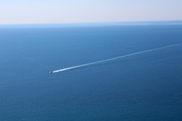 Mare azzurro con motoscafo e scia bianca