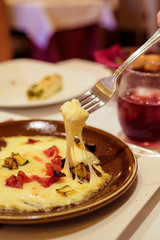 Cheese Fondue on a fork in an italian restaurant