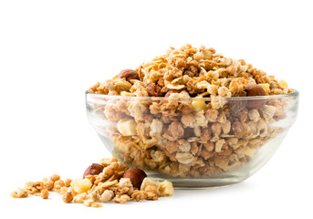 Granola in a glass plate and scattered on a white, isolated.