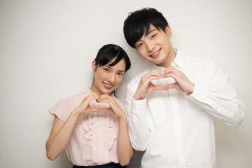 ハートマークを作る男女カップル