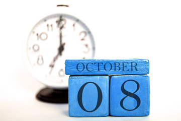 october 8th. Day 8 of month, handmade wood calendar and alarm clock on blue color. autumn month, day of the year concept