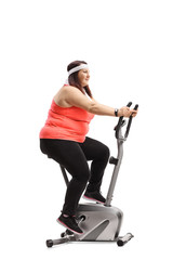 Corpulent woman exercising on a stationary bike