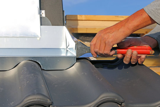 Dachdecker arbeitet an der Kaminverkleidung