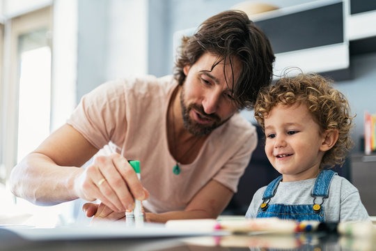 Adorable father and son drawing at home