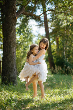 Girl lifting sister in forest